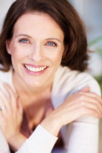 Closeup portrait of a cheerful middle aged woman with hands crossed